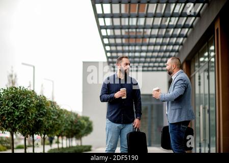 Zwei Kollegen bei einer Kaffeepause vor dem Geschäftsgebäude Stockfoto
