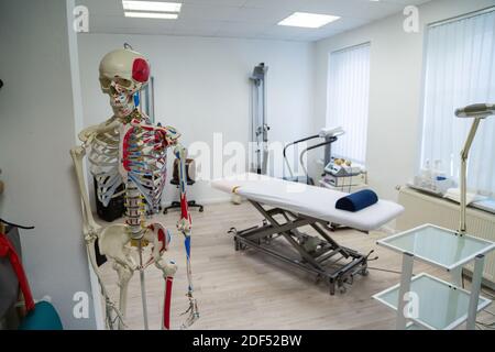 Medizinischer Schrank für Physiotherapie mit Massageliege und Skelett Stockfoto