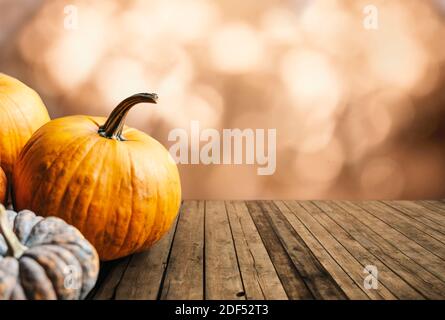 Herbst Kürbisse Stillleben auf vintage Holztisch und Bokeh Hintergrund. Thanksgiving Familie Abendessen Grußkarte Design. Halloween Kürbis Dekoration Stockfoto