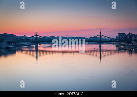 Blick auf die Szabadag-Brücke, die sich bei Sonnenaufgang in der Donau spiegelt, Budapest, Ungarn, Europa Stockfoto