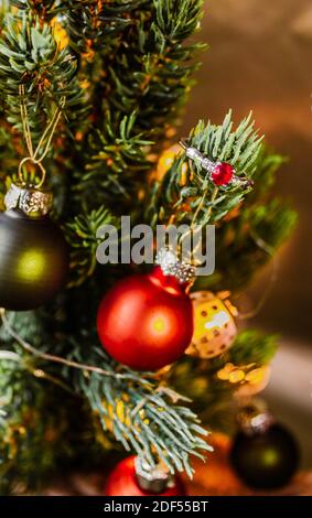 Silberner Verlobungsring mit rotem Rubin auf einem Zweig von geschmückten Weihnachtsbaum. Stockfoto