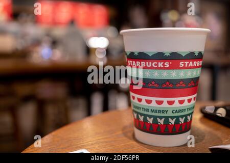 Eine Kaffeetasse aus Papier, die speziell für Weihnachten auf dem Tisch in einem Starbucks-Geschäft gemacht wurde. Stockfoto