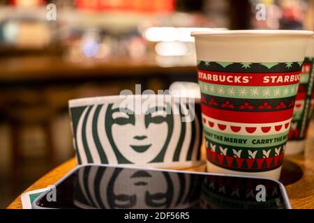 Eine Kaffeetasse aus Papier, die speziell für Weihnachten auf dem Tisch in einem Starbucks-Geschäft gemacht wurde. Stockfoto