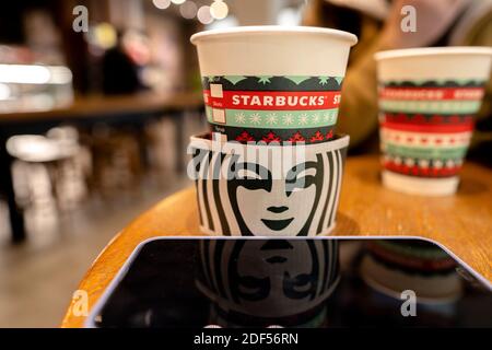 Eine Kaffeetasse aus Papier, die speziell für Weihnachten auf dem Tisch in einem Starbucks-Geschäft gemacht wurde. Stockfoto