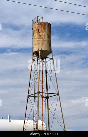 Eine vertikale Aufnahme eines alten, rostigen Wasserturms gegen einen bewölkten Himmel Stockfoto