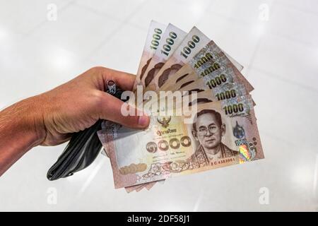 Thai Geldscheine 8000 Thai Baht halten in der Hand auf weißem Hintergrund. Stockfoto
