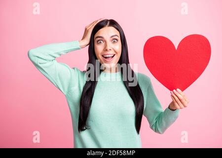 Foto-Porträt von geschockten Frau berühren Kopf mit einer Hand Halten große rote Herz Postkarte isoliert auf pastellrosa gefärbt Hintergrund Stockfoto
