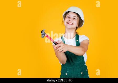 Fröhliche Kinderarbeiter mit Gebäude Uniform und Hammer-Werkzeug, Werkzeugladen. Stockfoto