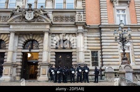 Hamburg, Deutschland. Dezember 2020. Vor dem Eingang zum Bezirksgericht stehen Polizeikräfte. Hier beginnt der Prozess gegen fünf Angeklagte wegen besonders schwerer Friedensverletzung bei Protesten gegen den G20-Gipfel in Hamburg. Quelle: Daniel Bockwoldt/dpa/Alamy Live News Stockfoto