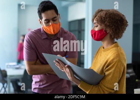 Gemischter Mann und Frau tragen Masken in einem Büro Stockfoto