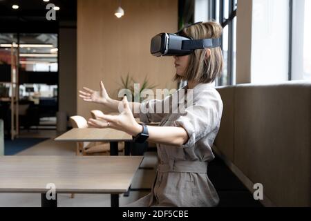 Asiatische Geschäftsfrau trägt Virtual-Reality-Headset im kreativen Büro Stockfoto