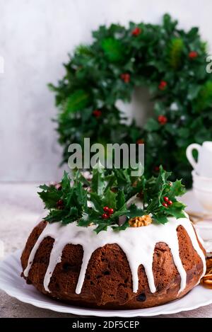 Weihnachten hausgemachten dunklen Schokolade gebündelt Kuchen mit Holly Beere verziert Äste auf Stein Stockfoto