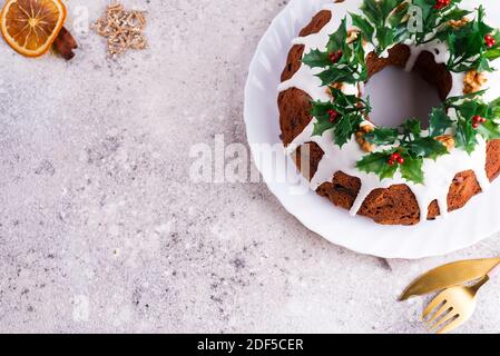 Weihnachten hausgemachten dunklen Schokolade gebündelt Kuchen mit Holly Beere verziert Äste auf Stein Stockfoto