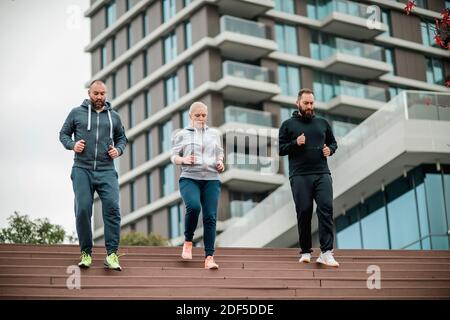 Drei junge Freunde laufen auf der Treppe Stockfoto
