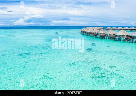 Sommerlandschaft und Seestang als tropischer Hintergrund. Tolle Aussicht von oben, luxuriöse Wasserbungalows, Urlaubsstimmung. Makellos klar Stockfoto