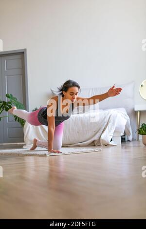 afroamerikanische Frau, die zu Hause Pilates praktiziert. Vertikales Foto. Stockfoto