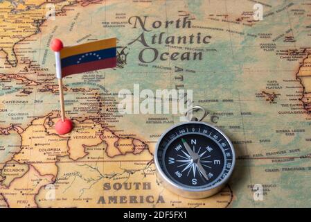 Flagge Venezuelas und Kompass auf der Weltkarte. Das Konzept von Reisen und Tourismus. Stockfoto