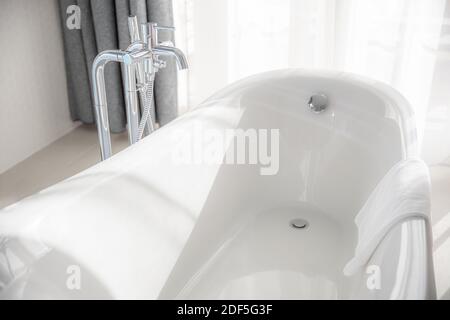 Sauberes Bad, moderne Badewanne, weiße Hygiene, sauberer moderner Stil. Hotel Immobilien, Luxus Wellness Stil Freizeit Pflege. Sonnige Inneneinrichtung Stockfoto