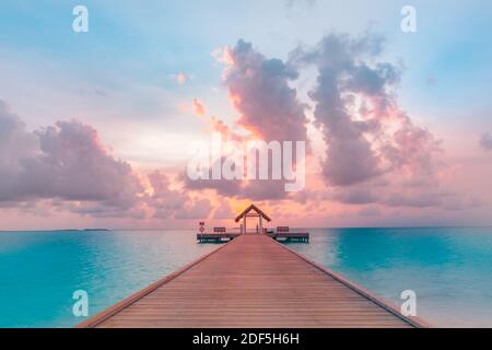 Sonnenuntergang auf den Malediven Insel, Luxus Water Villas Resort und hölzernen Pier. Schönen Himmel und Wolken und Strand Hintergrund für Sommer Urlaub Stockfoto