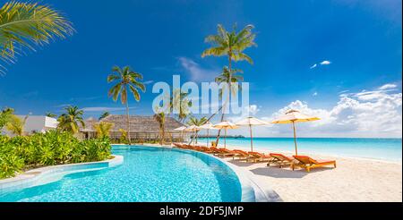 Strandlandschaft. Luxuriöses Strandresort mit Pool und Liegen oder Liegen unter Sonnenschirmen mit Palmen, Urlaub, Urlaub Stockfoto