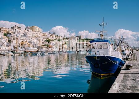 Sciacca Sizilien Oktober 2020, Fischerboote und Menschen reparieren Netze in der bunten Stadt Sciacca mit Blick auf ihren Hafen. Provinz Agrigento, Sizilien. Hochwertige Fotos Stockfoto