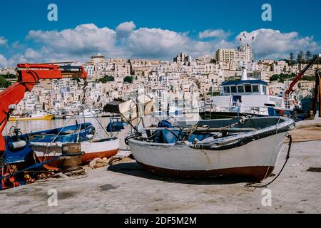 Sciacca Sizilien Oktober 2020, Fischerboote und Menschen reparieren Netze in der bunten Stadt Sciacca mit Blick auf ihren Hafen. Provinz Agrigento, Sizilien. Hochwertige Fotos Stockfoto