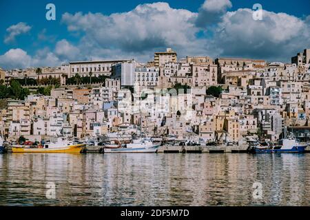 Sciacca Sizilien Oktober 2020, Fischerboote und Menschen reparieren Netze in der bunten Stadt Sciacca mit Blick auf ihren Hafen. Provinz Agrigento, Sizilien. Hochwertige Fotos Stockfoto