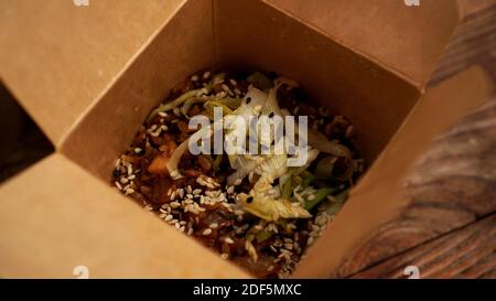 Schachtel mit gebratenem Reis mit Gemüse und Fleisch. Leckere Mischung. Chinesisches Fast-Food-Konzept. Stockfoto