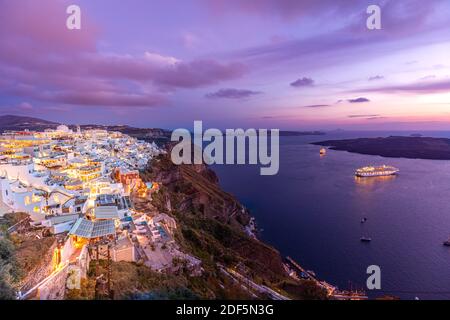 Santorini, Griechenland. Berühmte Sonnenuntergangsansicht der traditionellen weißen Architektur Santorini Landschaft mit Blumen im Vordergrund. Sommerurlaub Luxusreise Stockfoto