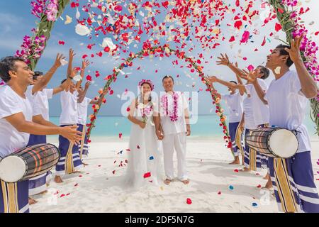 10.08.19 Inseln der Malediven. Junge asiatische paar küssen bei Hochzeitsempfang unter Blumen. Liebe Romantik Hochzeitszeremonie weißen Sandstrand in der Nähe des Meeres Stockfoto