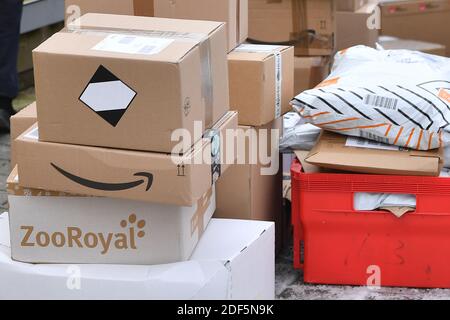 München, Deutschland. Dezember 2020. Paketvolumen und Online-Handel boomen in Zeiten der Corona-Virus-Pandemie. Amazon-Pakete befinden sich vor einer Packstation. DHL, Paket, Pakete, Paketdienst, liefern, liefern, entladen, Versand, Transporter, Handwagen. Quelle: dpa/Alamy Live News Stockfoto