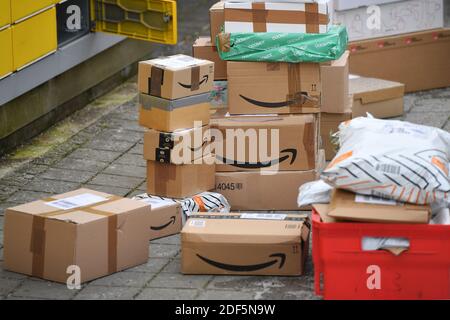 München, Deutschland. Dezember 2020. Paketvolumen und Online-Handel boomen in Zeiten der Corona-Virus-Pandemie. Amazon-Pakete befinden sich vor einer Packstation. DHL, Paket, Pakete, Paketdienst, liefern, liefern, entladen, Versand, Transporter, Handwagen. Quelle: dpa/Alamy Live News Stockfoto