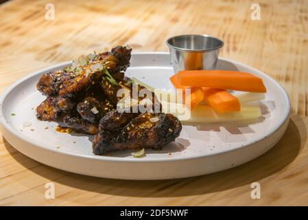 Hähnchenflügel im mexikanischen Stil auf weißem Teller. Stockfoto