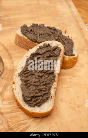 Zwei Brotscheiben mit einer dicken Aufstreuung von Tapenade Stockfoto