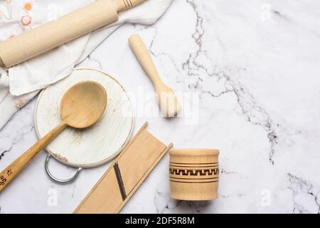 Küchengeräte aus Holz auf weißem Marmortisch, Blick von oben Stockfoto