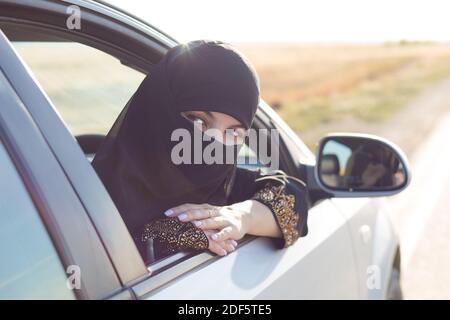 Frau Autofahrer schaut zurück und schaut zurück., Stockfoto