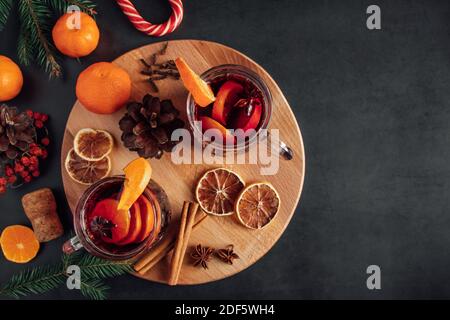 Heißer Glühwein in Glasbecher. Warmes Wintergetränk mit Gewürzen und Früchten. Stockfoto
