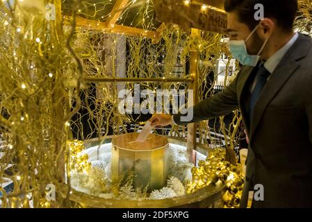 London, Großbritannien. Dezember 2020. Ein Mitarbeiter wünscht sich bei der Einführung der „Feierlichen Wünsche aus dem Savoyen“, der neuen Weihnachtsdekoration und des neuen „Wunschbrunnen“ im Savoy Hotel, das nach der Sperrung während der laufenden Coronavirus-Pandemie wieder eröffnet wird. Im Rahmen einer Charity-Initiative zugunsten der Hospitality Action, die in Not gerehene Hospitality-Mitarbeiter unterstützt, und der Connection at St. Martin in the Fields, die der Obdachlosen-Gemeinschaft in und um den Strand hilft, können die Besucher Wünsche in ein neues goldenes „Wunschbrunnen“ fallen lassen. Kredit: Stephen Chung / Alamy Live Nachrichten Stockfoto
