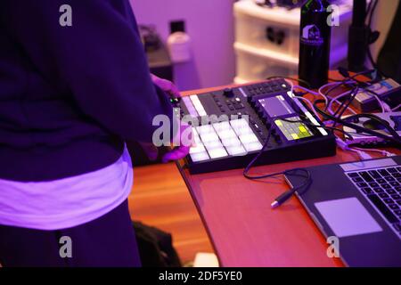 Eine Nahaufnahme eines Mannes, der Musik macht, schlägt und Geräusche mit einer Trommeleinheit Stockfoto