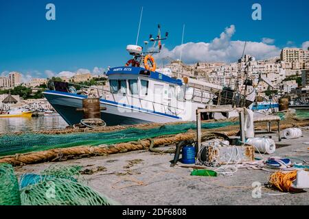 Sciacca Sizilien Oktober 2020, Fischerboote und Menschen reparieren Netze in der bunten Stadt Sciacca mit Blick auf ihren Hafen. Provinz Agrigento, Sizilien. Hochwertige Fotos Stockfoto