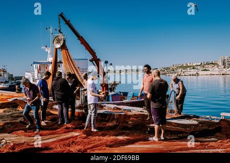 Sciacca Sizilien Oktober 2020, Fischerboote und Menschen reparieren Netze in der bunten Stadt Sciacca mit Blick auf ihren Hafen. Provinz Agrigento, Sizilien. Hochwertige Fotos Stockfoto