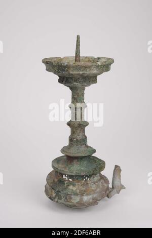 Candlestick, Anonymous, ca. 1450, Guss, Allgemein: 34 x 19.6 x 15,2cm 340 x 196 x 152mm, Löwe, der Kerzenständer ruhte ursprünglich auf drei Löwen, von denen nur einer erhalten ist. Die gewölbte Basis ist mit Formteilen und achtmal einem fünf-Pass-Ornament verziert. Am Fuß, der oben von einer freitragenden Kante begrenzt wird, erhebt sich der kegelförmige hohle, profilierte Stamm, der zwei ringförmige Knoten hat, von denen der untere den größten Durchmesser hat. Der Stamm endet in einer ca. 3 cm tiefen Fettfalle, die acht Mal an der senkrechten Wand mit einem fünfstufigen Ornament verziert ist. Die Kante hat acht Stockfoto