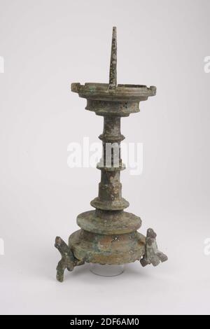 Candlestick, Anonymous, ca. 1450, gegossen, Allgemein: 47 x 16cm 470 x 160mm, Löwe, der Kerzenständer ruht auf drei Löwen, die an drei genieteten Nocken befestigt sind. Die gewölbte Basis hat eine fünfstufige Dekoration im vertikalen Hohlrahmen. Der Fuß endet in einer stark hervorstehenden Kante. Es gibt einen profilierten, ringförmigen Knoten um eine Verdickung an der Unterseite der Welle. Darüber ist er leicht zulaufend und hat dort noch zwei Knoten. Sie endet in der profilierten Fettfalle mit sechs Neigungen und mit sechs fünf Schritten in der vertikalen Kante. Die Innenseite der Fettabscheider fällt Schritt für Schritt nach unten Stockfoto