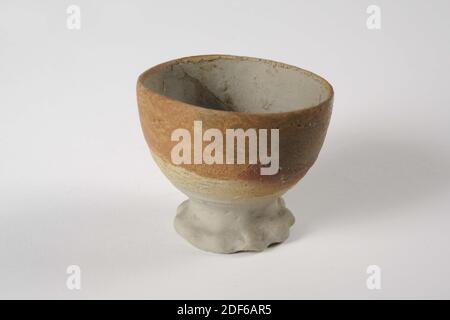 becher, Anonymous, 15. Jahrhundert, Steinzeug, Tonglasur, Allgemein: 6,2 x 7,8cm 62 x 78mm, kleiner Trinkbecher aus grauem Steinzeug, teilweise außen mit lachsrosa Tonglasur überzogen. Der Becher steht auf einer hohen Basis mit eingeklemmter Kante und hat eine halbrunde Form. In der Wand eine große moderne Ergänzung, 1934 Stockfoto