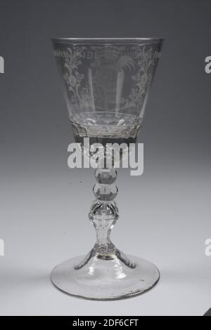 Glas, 3. Viertel 18. Jahrhundert, Allgemein: 20.2 x 9.3cm 202 x 93mm, Kelchdurchmesser: 8,8cm, Kartusche, V.O.C. Glas aus farblosen Glas. Der Kelch hat eine ziemlich hohe gewölbte Basis mit einem facettierten Fußring. Facettierter Stiel mit drei Knöpfen, dessen Boden balusterförmig ist. Eine gedehnte Luftblase im gesamten Stängel. In dem sehr massiven, facettierten Kelchboden, sechs Luftblasen: Eine in der Mitte, fünf um sie herum. An der Kelchwand wurde eine Rokoko-Kartusche mit einem Monogramm OVC [in einem], bedeckt von einer Grabkrone und umgeben von zwei blühenden Zweigen, gebohrt Stockfoto