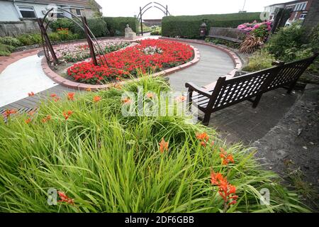 Troon, Gordon Brown Memorial Garden, Ayrshire, Schottland, Großbritannien. Ein schottischer internationaler Rugby-Spieler. Brown spielte als Schloss und wurde 30 Mal von Schottland gedeckelt. Rechts vom Eingang befindet sich eine Cairn mit einer Widmung an Brown. Die Cairn wird von einer Skulptur einer Rugby-Kugel überragt, die auf einer großen Distel liegt. Der Garten ist herrlich angelegt und wunderschön anzusehen. Stockfoto