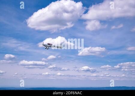 Kleine Trainerflugzeuge fliegen in der Luft, mitten in den Wolken. Horizontale Ansicht. Negatives Leerzeichen, gut zum Schreiben von Text. Geeignet für Hintergrund, Titelbild. Stockfoto