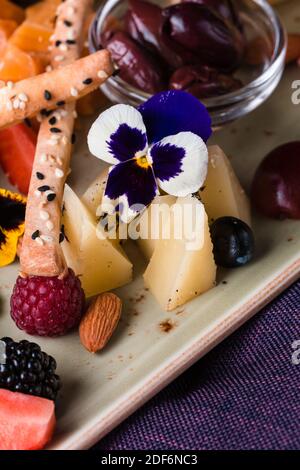 Käseplatte mit Trauben und Nüssen serviert. Verschiedene Käsesorten Camembert, Brie, Parmesan Blauschimmelkäse, Ziege mit Trauben, Gressini-Sticks, Cashews, Honig und Stockfoto