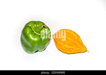 Gelbe bittere Kürbis zwischen grünen Paprika mit isoliertem Hintergrund, ungerade heraus Stockfoto