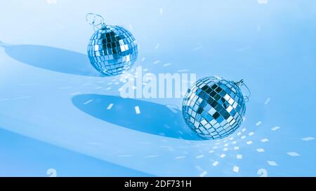 Zwei Diskokugeln auf blauem Hintergrund mit Schatten und Reflexionen Stockfoto